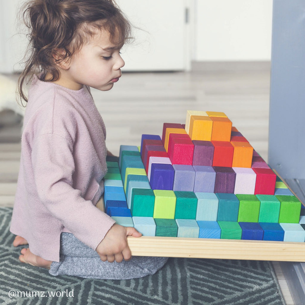 Bambino che gioca con la Piramide Grimm's, costruzioni educative in legno montessoriano